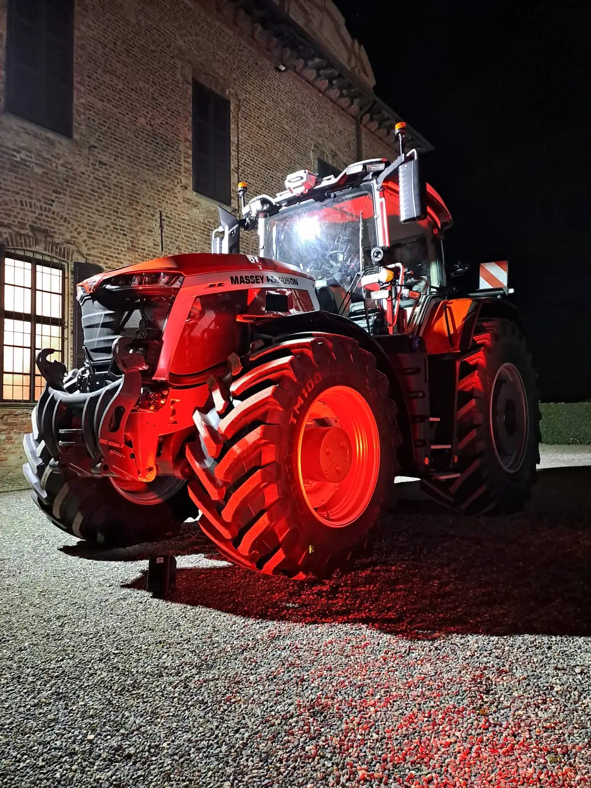 Massey Ferguson illuminato di rosso durante un evento notturno